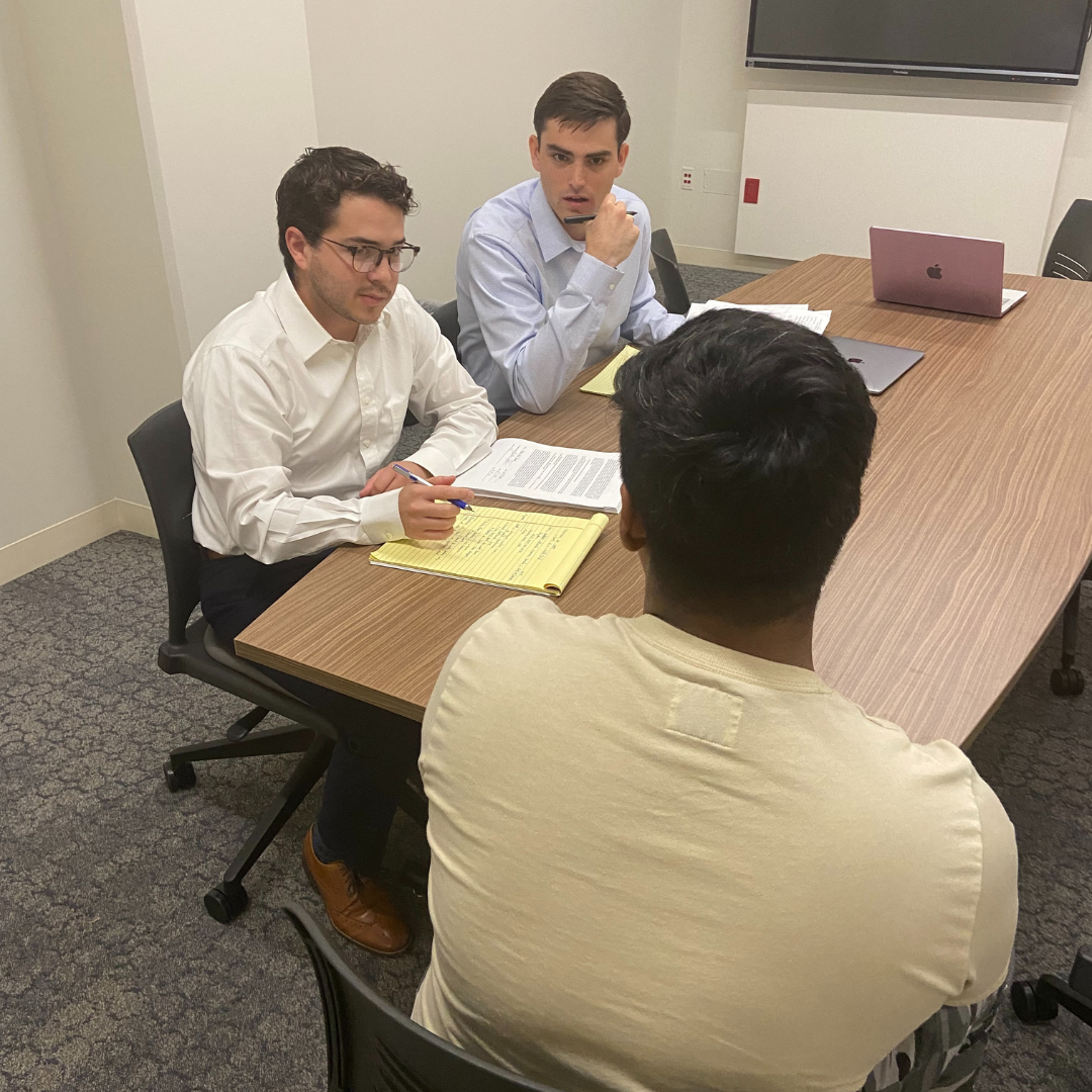 Clinic students, Pablo Lopez and Grayson Carnahan, preparing an asylum seeker for his merits hearing.